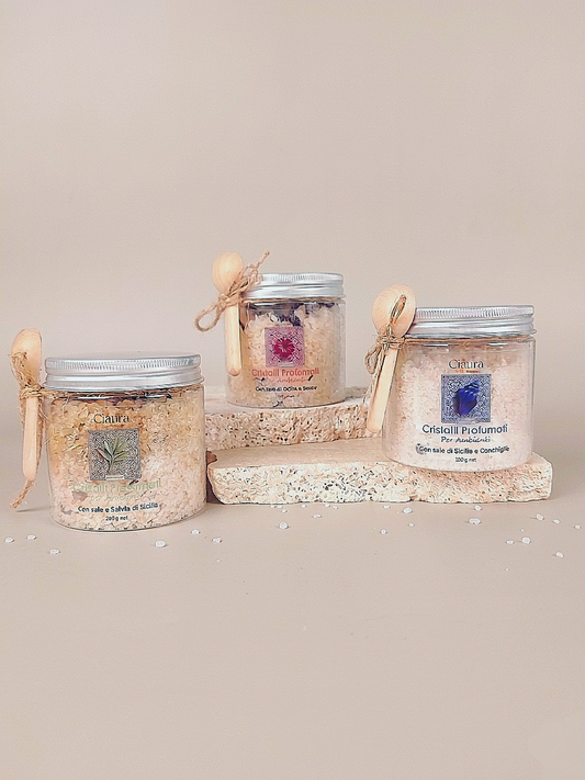 barattolo trasparente in pet che contiene cristalli profumati per ambiente a base di sale di sicilia di trapani e fiori essiccati di ibisco. con tappo in alluminio e  cucchino in legno dosatore